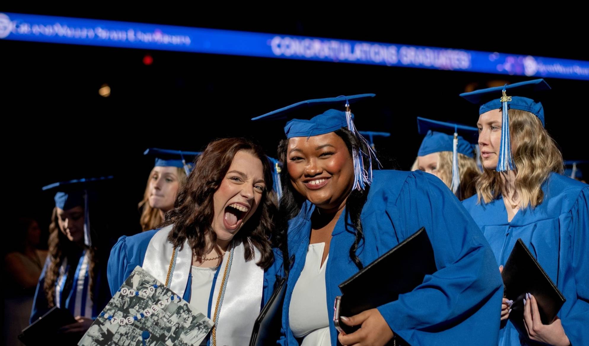 Two students smile during Commencement.